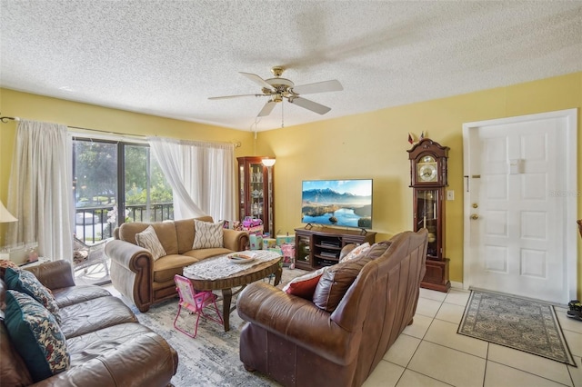 living room with ceiling fan, a textured ceiling, and light tile patterned floors