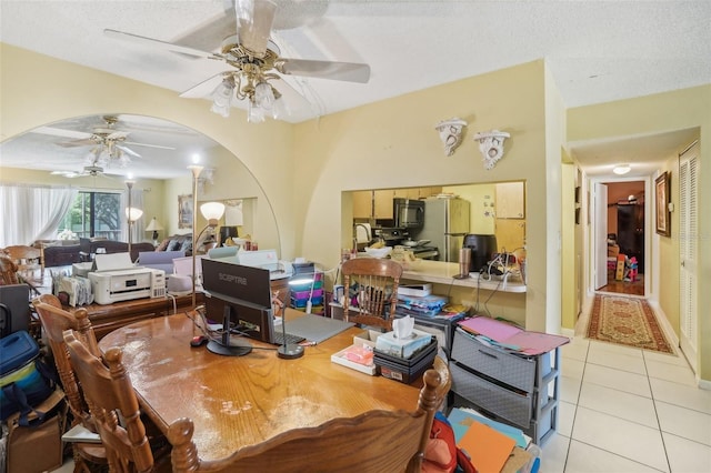 tiled dining space with ceiling fan and a textured ceiling