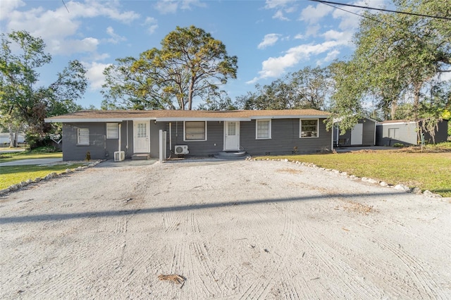 ranch-style house with a front yard and a storage shed