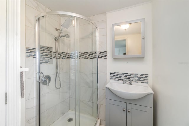 bathroom with vanity, a shower with shower door, and backsplash