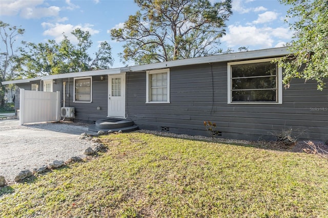 view of front of house featuring ac unit and a front lawn