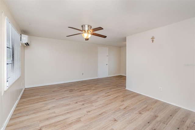 empty room featuring ceiling fan, light hardwood / wood-style floors, and a wall mounted AC