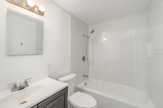 full bathroom with tiled shower / bath, vanity, and toilet