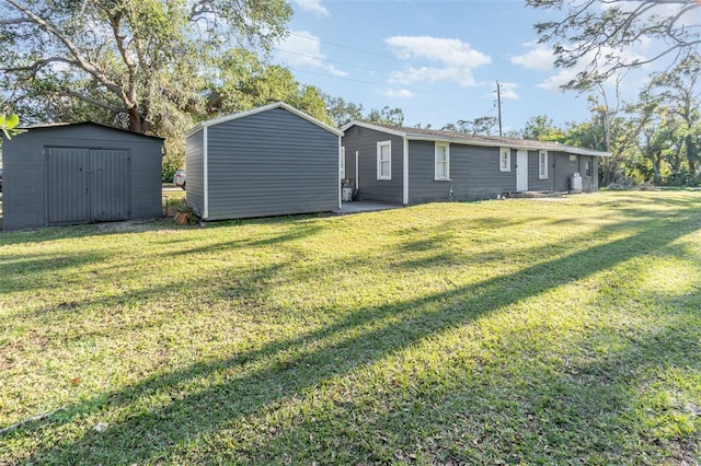 back of house featuring a lawn and a storage unit