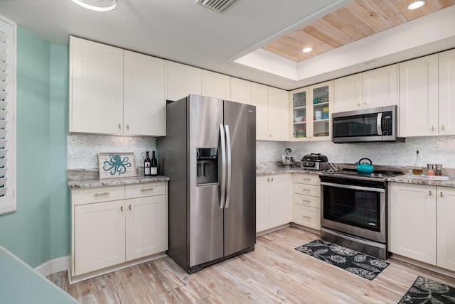 kitchen with appliances with stainless steel finishes, decorative backsplash, and white cabinetry