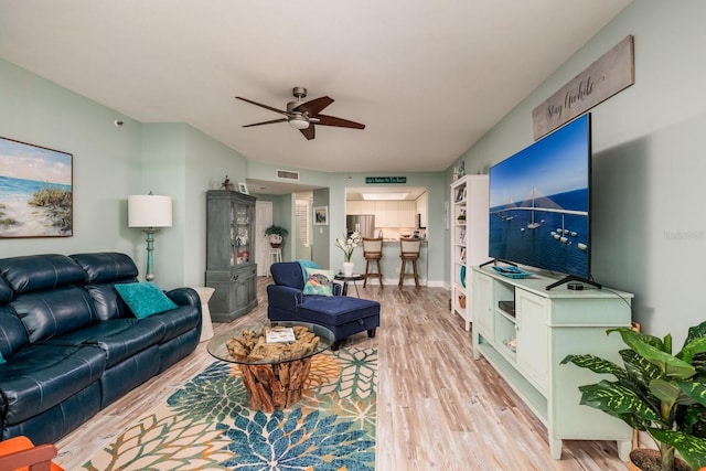 living room with light wood-type flooring and ceiling fan