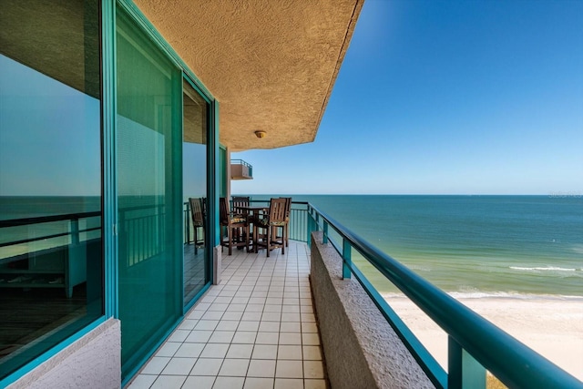 balcony featuring a water view and a view of the beach