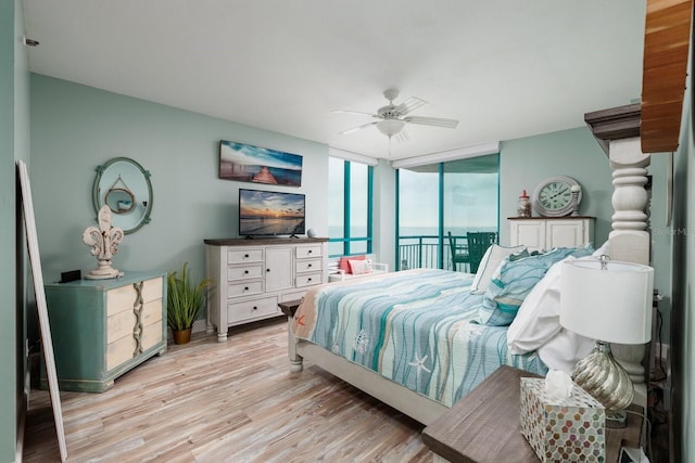 bedroom with ceiling fan, access to exterior, floor to ceiling windows, and light hardwood / wood-style flooring