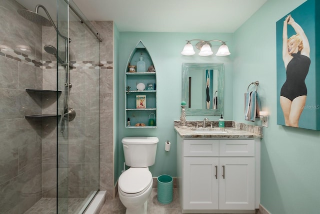 bathroom with toilet, vanity, and a tile shower