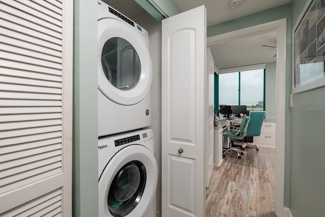 laundry room featuring light hardwood / wood-style flooring and stacked washer and dryer