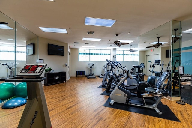 gym featuring ceiling fan and light hardwood / wood-style floors