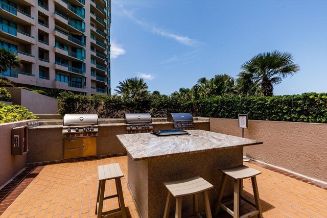 view of patio / terrace with an outdoor kitchen, a bar, and a grill