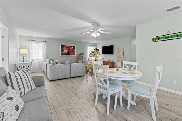 dining area with light wood-type flooring and ceiling fan