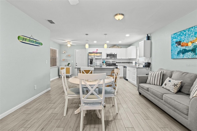 dining space featuring ceiling fan and sink