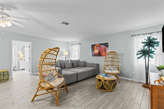 living room with a textured ceiling and ceiling fan