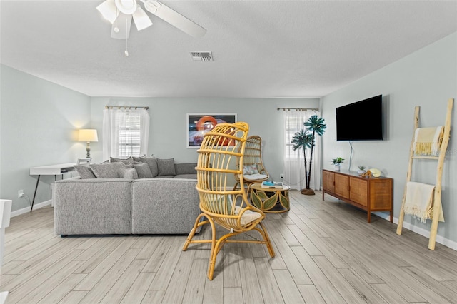 living room with ceiling fan and a healthy amount of sunlight