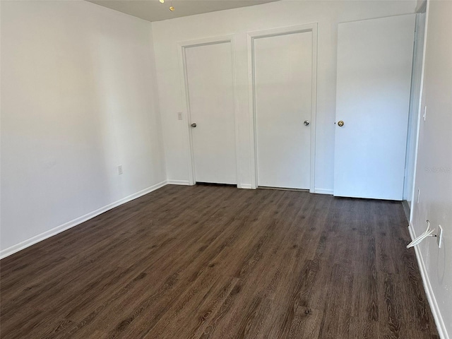 unfurnished bedroom with dark hardwood / wood-style flooring