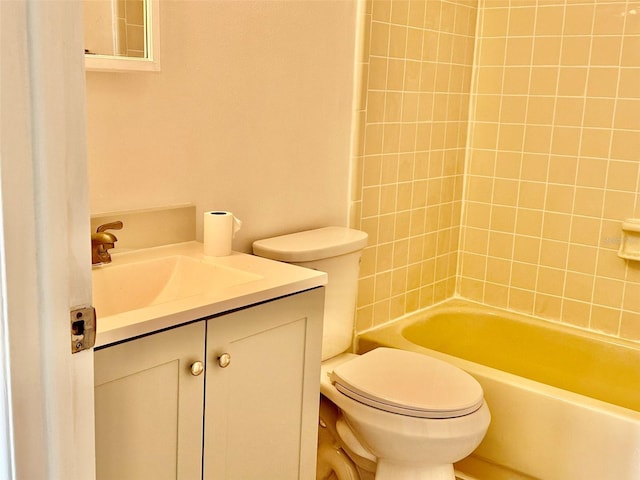 full bathroom featuring vanity, tiled shower / bath, and toilet