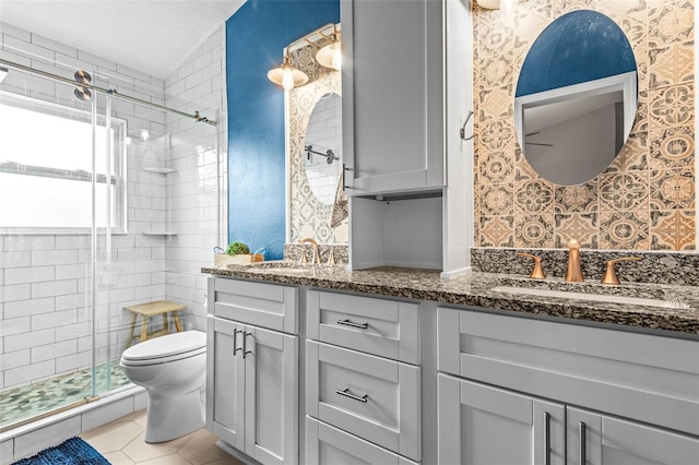 bathroom featuring toilet, tile patterned flooring, an enclosed shower, and vanity