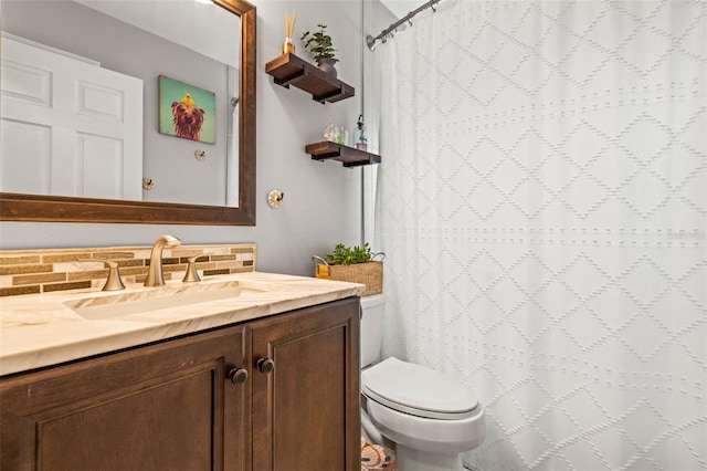 bathroom with toilet, vanity, walk in shower, and tasteful backsplash