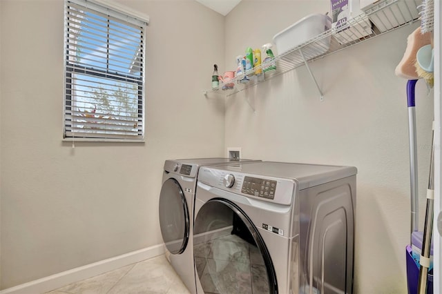 clothes washing area with light tile patterned flooring and independent washer and dryer