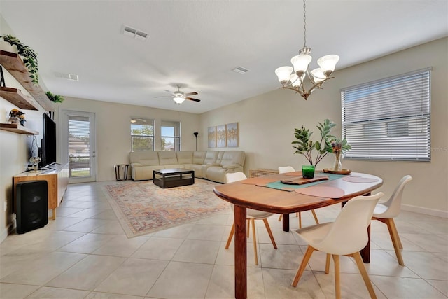 tiled dining space featuring ceiling fan with notable chandelier