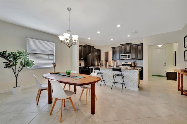 dining area featuring light tile patterned floors and an inviting chandelier