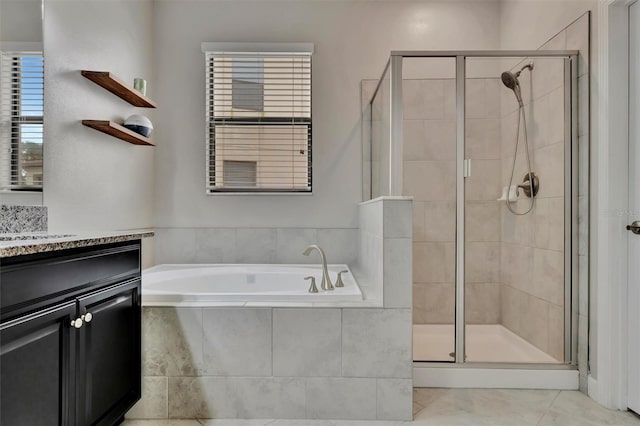 bathroom featuring tile patterned flooring, vanity, and shower with separate bathtub