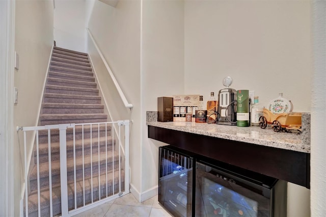 bar with light stone countertops, beverage cooler, and light tile patterned floors