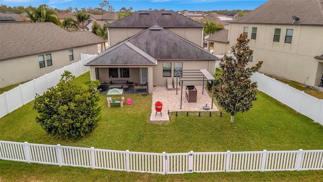 rear view of property with a yard and a patio