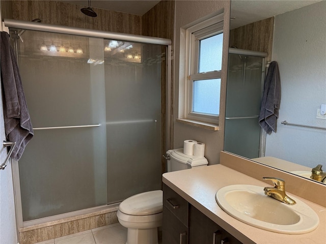 bathroom featuring toilet, an enclosed shower, tile patterned floors, and vanity