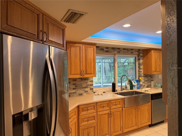 kitchen with tasteful backsplash, sink, stainless steel appliances, and light tile patterned flooring