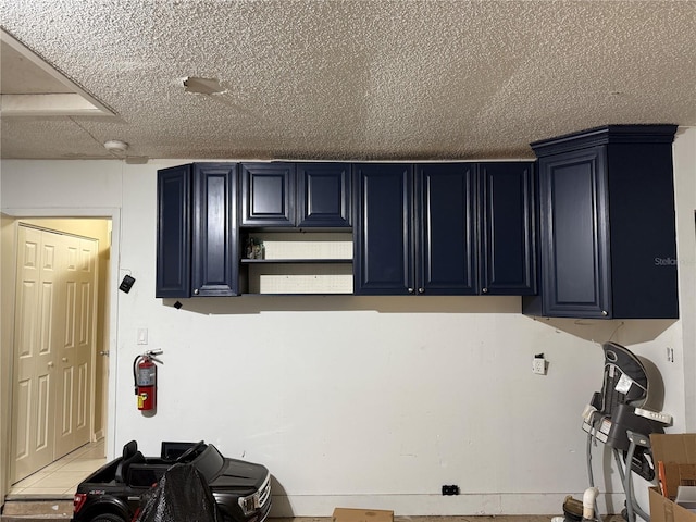 kitchen featuring blue cabinetry and a textured ceiling