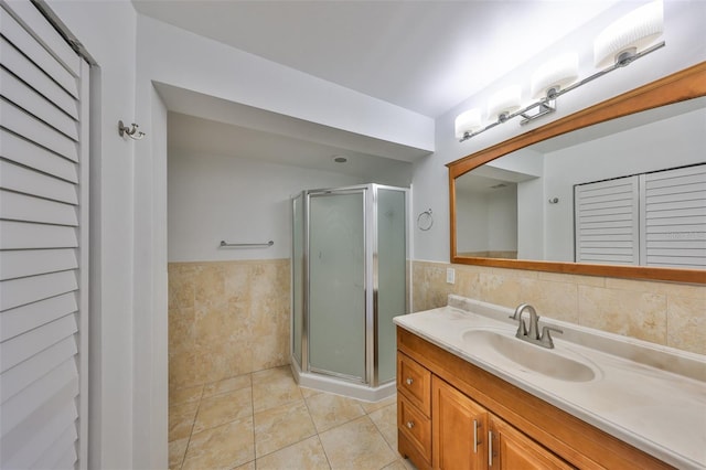 bathroom with tile patterned floors, walk in shower, tile walls, and vanity