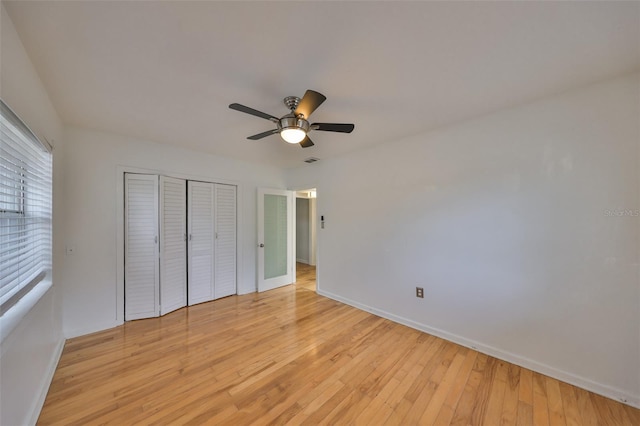 unfurnished bedroom featuring ceiling fan, a closet, and light hardwood / wood-style flooring