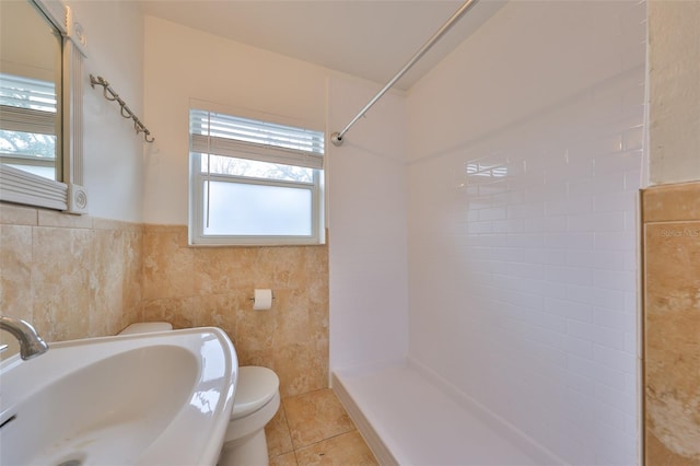 bathroom featuring sink, toilet, tile walls, and tile patterned floors