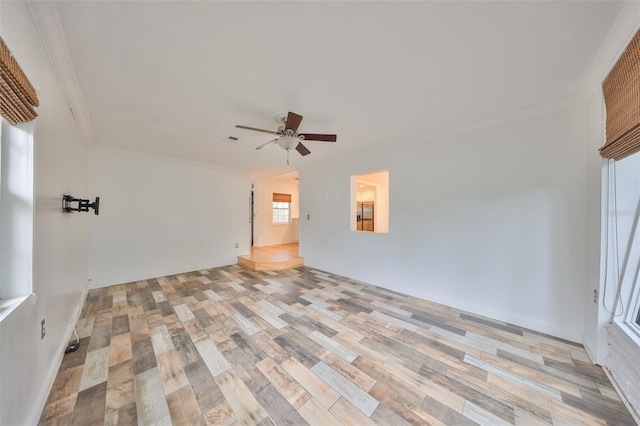 spare room featuring light wood-type flooring, ceiling fan, and crown molding