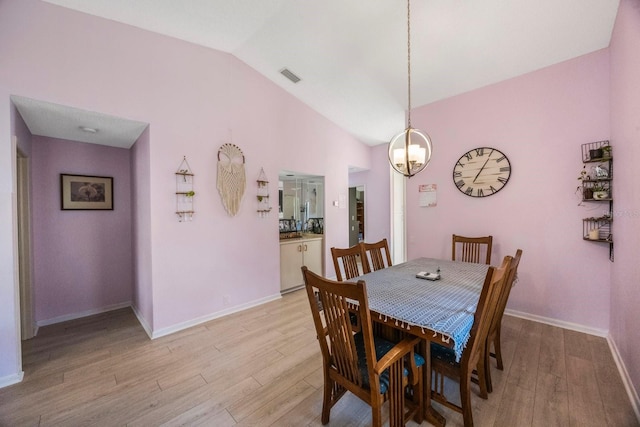 dining room featuring lofted ceiling and light hardwood / wood-style floors