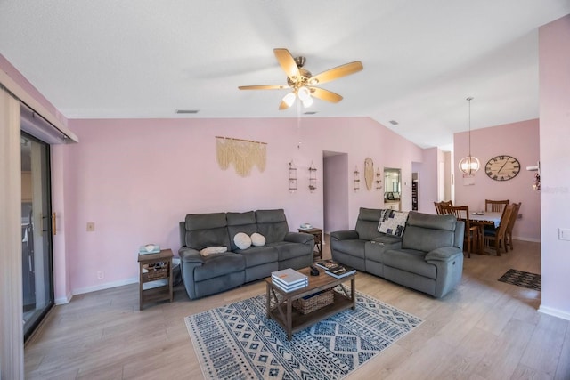 living room featuring ceiling fan, vaulted ceiling, and light hardwood / wood-style flooring