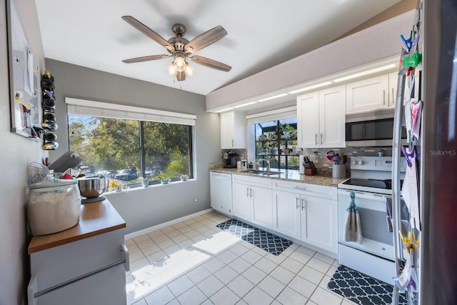 kitchen with stainless steel appliances, a healthy amount of sunlight, white cabinetry, and sink