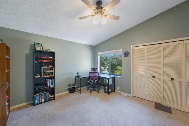 carpeted office featuring lofted ceiling, ceiling fan, and a textured ceiling