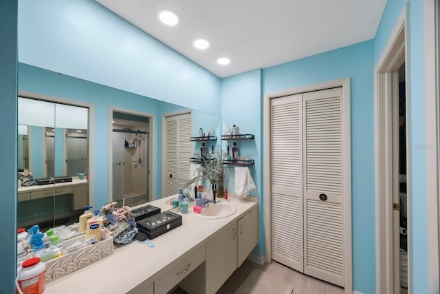 bathroom featuring a textured ceiling, tile patterned floors, and vanity