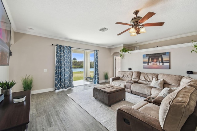 living room featuring ornamental molding, a textured ceiling, ceiling fan, and light hardwood / wood-style flooring