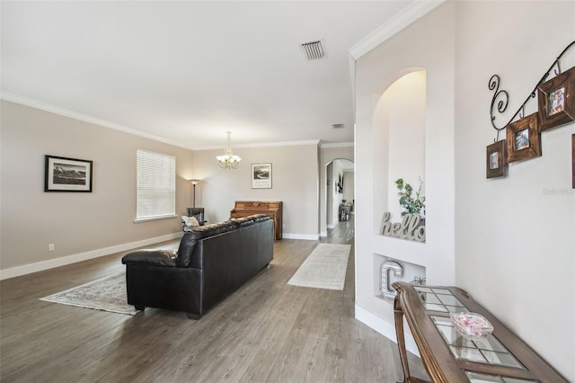 living room featuring an inviting chandelier, crown molding, and wood-type flooring