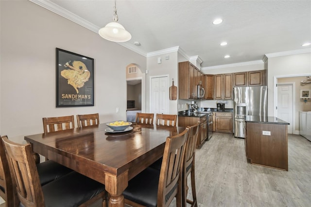 dining room with crown molding, washer and dryer, and light hardwood / wood-style flooring