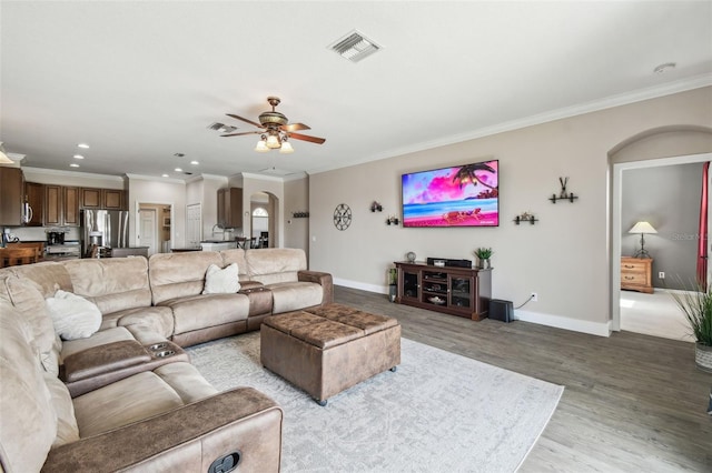 living room with crown molding, ceiling fan, and light hardwood / wood-style flooring