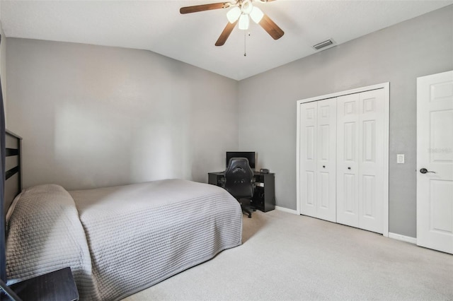 carpeted bedroom featuring ceiling fan, vaulted ceiling, and a closet