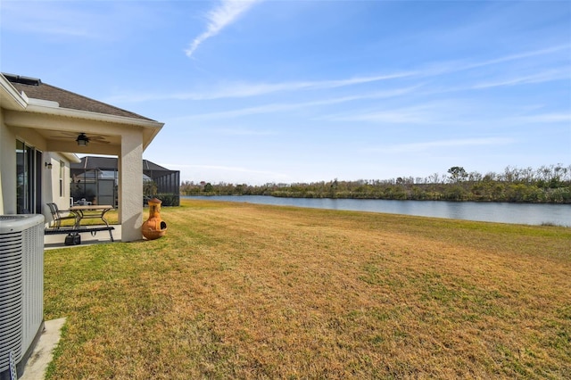 view of yard with a water view, a lanai, and central AC