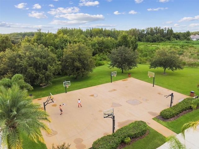 surrounding community featuring basketball hoop and a lawn