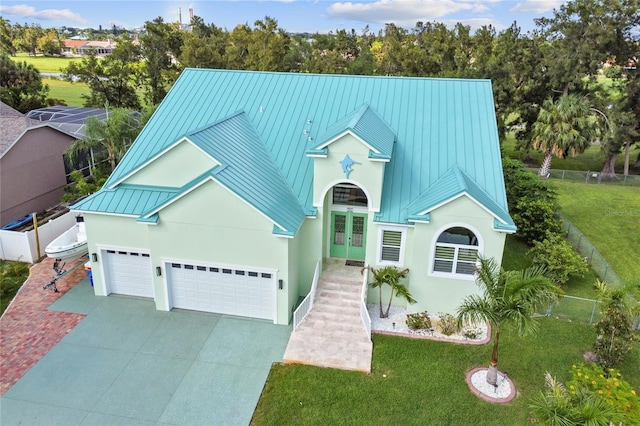 view of front of home with a front lawn, french doors, and a garage